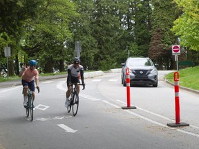 A car and a pair of cyclists in their lanes in Stanley Park on May 24, 2022.