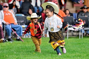 Two-year old Raiden and four-year-old Lexani Lindley play at a memorial event marking the first anniversary of the discovery of unmarked Indigenous child graves at the Tk'emlups Pow wow Arbour in Kamloops, B.C., May 23, 2022.