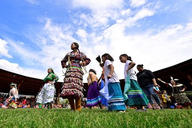 Jingle Dress dancers perform at a memorial event marking the first anniversary of the discovery of unmarked Indigenous child graves at the Tk'emlups Pow Wow Arbour in Kamloops, B.C., May 23, 2022.
