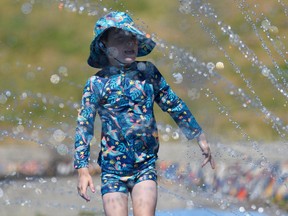 FILE PHOTO: Six-year-old Gigi Riccardi cools off at a splash pad during the scorching weather of a heatwave in Vancouver, British Columbia, Canada June 27, 2021. REUTERS/Jennifer Gauthier