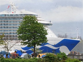 A cruise ships passes a tent encampment at CRAB Park in Vancouver on May 2, 2022.