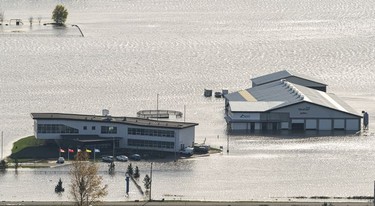 BEFORE: A farm and business on the Sumas prairie is surrounded by flood waters in Abbotsford, Nov., 17, 2021.