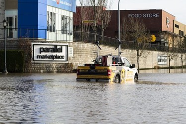 BEFORE: A traffic truck sits in flood waters outside Parallel Marketplace in Abbotsford, Nov., 17, 2021.