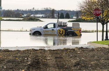 BEFORE: A traffic truck sits in flood waters outside Parallel Marketplace in Abbotsford, Nov., 17, 2021.