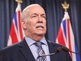 Premier John Horgan answers questions during a news conference in the press theatre at the legislature in Victoria, Friday, March 11, 2022. Police say they are investigating manure left at the front doors of British Columbia premier's local constituency office in Langford.