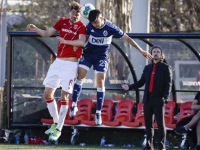 Vancouver Whitecaps midfielder Ryan Raposo, right, and Calgary Cavalry midfielder Charles Trafford go up for the ball during first half soccer action in the Canadian Championship quarter-finals in Calgary, Alta., Wednesday, May 25, 2022.THE CANADIAN PRESS/Jeff McIntosh