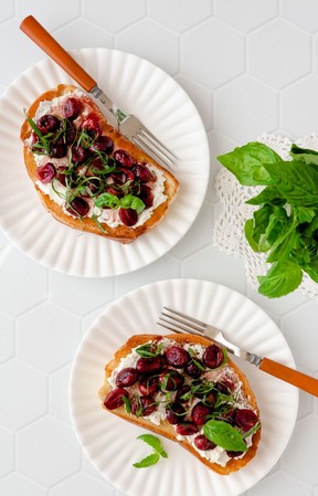 Toast mit Ricotta, gerösteten Trauben und Basilikum.