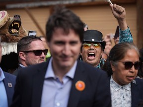 Skwelcampt, back right, from Turtle Island, shouts at Prime Minister Justin Trudeau as he arrives for a ceremony marking the one-year anniversary of the Tk’emlúps te Secwépemc announcement of the detection of the remains of 215 children at an unmarked burial site at the former Kamloops Indian Residential School, in Kamloops, B.C., on Monday, May 23, 2022.