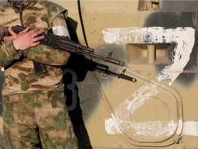 A service member of pro-Russian troops stands guard next to a combat vehicle, with the symbol "Z" seen on its side, before the expected evacuation of wounded Ukrainian soldiers from the besieged Azovstal steel mill in the course of Ukraine-Russia conflict in Mariupol, Ukraine May 16, 2022.