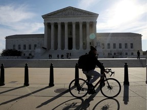 FILE PHOTO: A cyclist rides in front of the U.S. Supreme Court building in Washington, U.S. March 15, 2022. REUTERS/Emily Elconin/File Photo