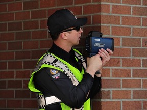 File photo of a Vancouver police officer watching for speeding drivers using a radar gun.