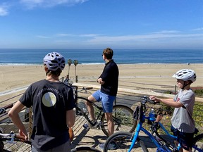Cyclists on a tour with The Bike Centre in Santa Monica stop to enjoy a view over the broad swath of sandy beach.