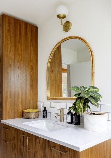 In the main bathroom, crisp subway tile balances warm custom teak cabinetry. Due to COVID delivery slowdowns, the brass hardware and fixtures were slow to arrive, but worth the wait.