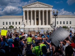 Law enforcement officers prepare to break up an altercation in front of the Supreme Court building following the announcement of the Dobbs v Jackson Women's Health Organization ruling on June 25, 2022 in Washington, DC.  The Court's decision in Dobbs v Jackson Women's Health overturns the landmark Roe v Wade case of 50 years, eliminating the federal right to abortion.