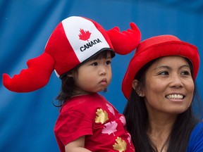 A woman holds her daughter while attending Canada Day celebrations in Vancouver on July 1, 2016.