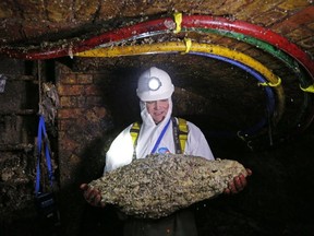 A sewer technician holds a "fatberg" as he works in the intersection of the Regent Street and Victoria sewer in London on December 11, 2014. Wet wipes reportedly make up 90 per cent of "fatbergs."