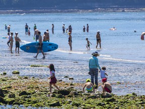 People dealing with heat wave at Ambleside Beach in West Vancouver in 2021.