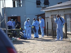 Forensic personnel investigate after the deaths of patrons found inside the Enyobeni Tavern, in Scenery Park, outside East London in the Eastern Cape province, South Africa, Sunday, June 26, 2022.