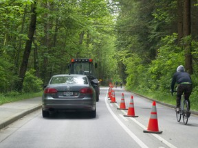 Vehicles and cyclists in their lanes on Stanley Park Drive in Stanley Park.