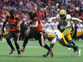 B.C. Lions' T.J. Lee, right, intercepts a pass intended for Edmonton Elks' Jalin Marshall during the first half of CFL football game in Vancouver, on Saturday, June 11, 2022.