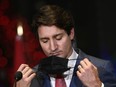 Prime Minister Justin Trudeau removes his mask before answering questions at an announcement in Ottawa, on Wednesday, Dec. 15, 2021.