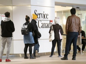 People line up at a Service Canada office in Montreal on Thursday, March 19, 2020.