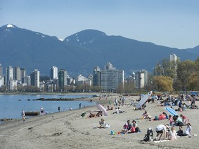 People enjoying the warm weather at Kitsilano Beach in Vancouver.