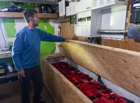 Darryl McKenzie, executive director of the Cedar Coast Field Station on Vargas Island near Tofino, B.C., with a bank of batteries that are fed by solar panels on the roof. The station offers researchers, students and others the opportunity to live off-grid.