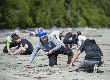 Max Who (centre) joined fellow students from West Point Grey Academy to work on fire-making skills on the beach near the Cedar Coast Field Station on Vargas Island near Tofino, B.C. The station offers researchers, students and others the opportunity to live off-grid.