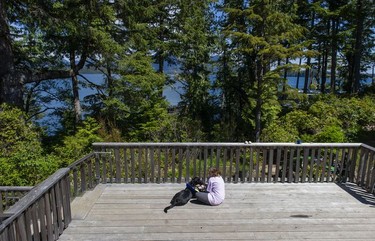 Volunteer Alexis Moerman and Buck share a moment on a deck overlooking the ocean at the Cedar Coast Field Station on Vargas Island near Tofino, B.C. The station offers researchers, students and others the opportunity to live off-grid.