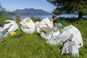 Marcie Callwaert, an educator at the Cedar Coast Field Station on Vargas Island near Tofino, B.C., with bags of plastic collected from the shore. The station offers researchers, students and others the opportunity to live off-grid.