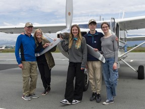 Ian and Michelle Porter, with their children Chris, Sydney (striped shirt) and Samantha, prepare their plane at Pitt Meadows airport on June 15. They're flying around the world for charity.