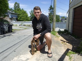 Duncan McDonald hält eine gebrochene Kette, die sein handgefertigtes 14-Fuß-Boot mit dem Namen Salor Do Dat an einer Stange in seiner Gasse in Vancouver festhielt.