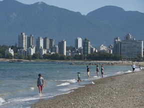 People do what they can to stay cool at Kits Beach in Vancouver, BC during a heat wave in August 2021.