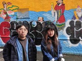 Artists Sean Cao and Katharine Yi in front of their mural, after it was vandalized in Chinatown in March.