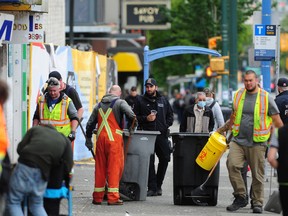 Sanitation workers clean the sidewalks in the Downtown Eastside on June 19, 2022. These city workers are different from the 'street sweepers' of the city's engineering department.