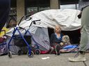 Fay Burns and her dog, Mr. Boo, sit inside their latest tent, on the sidewalk of East Hastings Street, between Columbia and Carroll, in Vancouver.