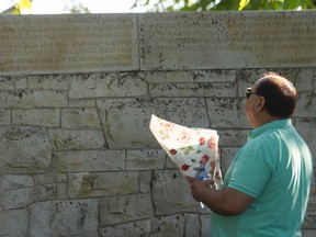A person at the Air India memorial in Stanley Park on June 23, 2022, looks up at the names of the last carved in stone.