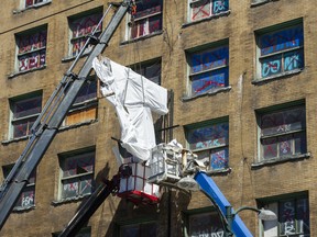 The Balmoral Hotel sign is removed from the building on East Hastings Street on Sunday.