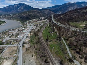 The burned-out remains of businesses and properties destroyed by last year's devastating wildfire are seen along with rail lines, centre, and the Trans-Canada Highway, upper right, in Lytton, B.C., on Saturday, May 21, 2022.&ampnbsp;The fire-ravaged community of Lytton, B.C., will get $77 million from the federal government to help it rebuild a fire-resistant and energy-efficient community.