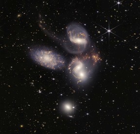 In this handout photo provided by NASA, NASA's James Webb Space Telescope reveals Stephans Quintet, a visual grouping of five galaxies, in a new light on July 12, 2022 in space. This enormous mosaic is Webb's largest image to date, covering about one-fifth of the Moons diameter. It contains over 150 million pixels and is constructed from almost 1,000 separate image files. The information from Webb provides new insights into how galactic interactions may have driven galaxy evolution in the early universe.