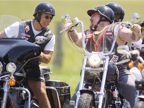 Hells Angels Toronto "Downtown" chapter member Donny Petersen (L) shares a laugh with an Ontario Nomads member during a summer party at their Casaerea marina complex in the summer of 2003.