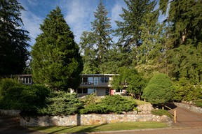 El exterior de la casa de los Brooks en el vecindario Delbrook de North Vancouver, ubicado entre los árboles.