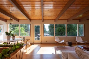 The open living space of the Brooks' house, where there is no separation between the dining and living rooms, and large windows and a deck bring the outside in.