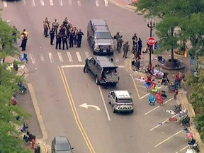Police deploy after gunfire erupted at a Fourth of July parade route in the wealthy Chicago suburb of Highland Park, Illinois, U.S. July 4, 2022 in a still image from video.