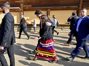Prime Minister Justin Trudeau, back centre, walks with Tk'emlups te Secwepemc Chief Rosanne Casimir at a memorial event in Kamloops, B.C., on May 23.