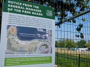 A notice posted on a fence blocking a shaded part of CRAB Park indicates where people can pitch their tents during the day on July 30, 2022.
