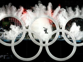 A snowboarder flies through the Olympic Rings, triggering an explosion of snow and ice at B.C. Place during the opening ceremony of the 2010 Winter Olympics in Vancouver on February 12, 2010.