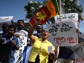Demonstrators shout slogans against interim Sri Lanka's President Ranil Wickremesinghe during a protest in front of the Fort railway station in Colombo on July 19, 2022. (Photo by Arun SANKAR / AFP)