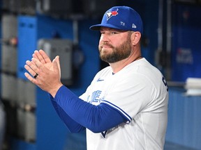Toronto Blue Jays interim manager John Schneider applauds the ceremonial first pitch before the game against the Philadelphia Phillies at Rogers Centre.